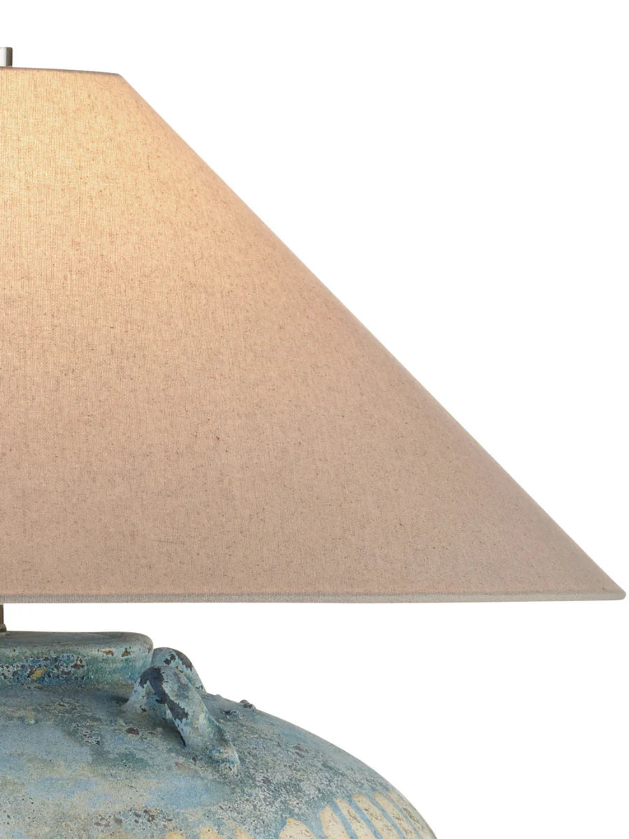Table lamp with a textured base and beige lampshade on a white background